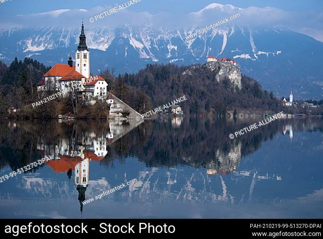 19 February 2021, Slovenia, Bled: The Church of the Assumption of the Virgin Mary on the island of Blejski Otok in Lake Bled at the foot of the Pokljuka plateau