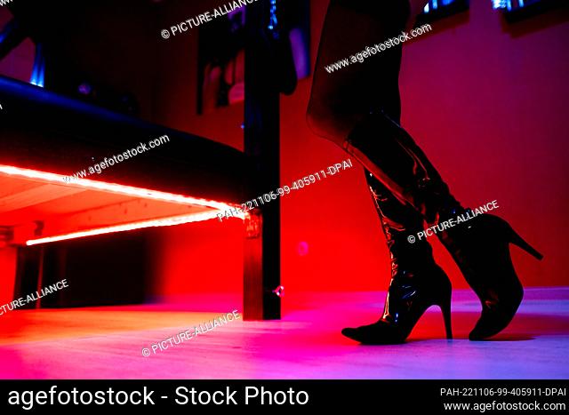06 November 2022, Lower Saxony, Oldenburg: A prostitute stands in front of the red lighting under a bed in a studio. During a press conference