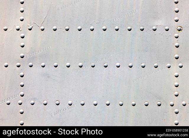 Grey metal surface with rivets as background