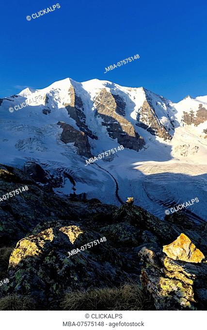 First sunlight illuminates rocks with Palù Peaks and Vedret Pers Glacier in the background, Diavolezza Refuge, Bernina Pass, Engadin, Graubünden, Switzerland