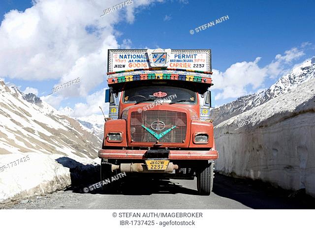 Pass road, Manali-Leh highway, old red Tata truck on road between snow wall near Keylong, Lahaul and Spiti district, Himachal Pradesh, India, South Asia