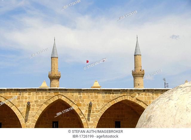 Arches of the old caravanserai Bueyuek Han with domed tower, in the back the minarets of the Selimiye Mosque, Nicosia, Lefkosa