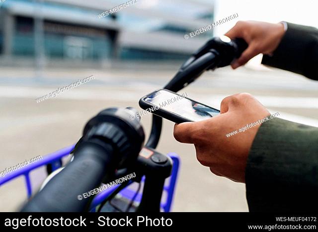 Businessman unlocking bicycle through smart phone