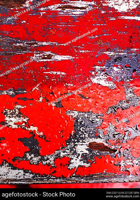 08 January 2023, Berlin: 08.01.2023, Berlin. Chipped remains of paint on old wooden beams form colorful, random structures and patterns on Oranienstrasse in...