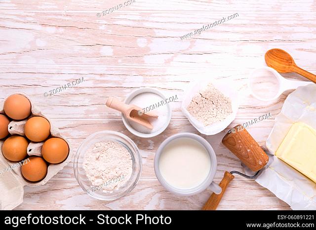Assorted baking ingredients and kitchen utensils for cooking and baking on wooden background