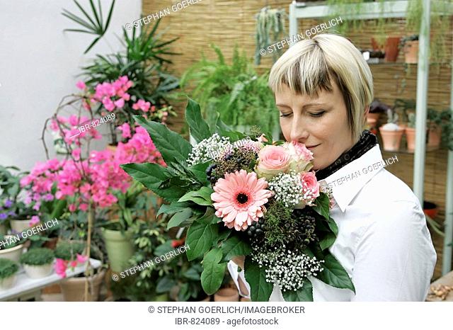 Young woman smelling a bouquet of flowers