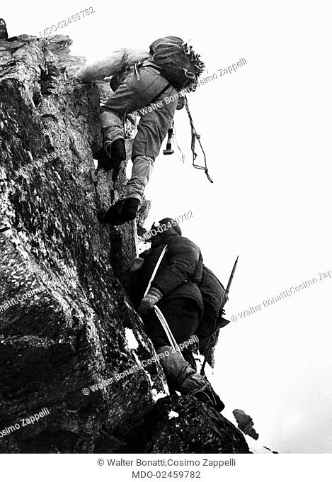 Italian mountaineers Walter Bonatti and Cosimo Zappelli climbing the Grandes Jorasses. Courmayeur, January 1963