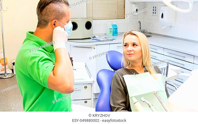 Dentist taking off protective mask after teeth treatment