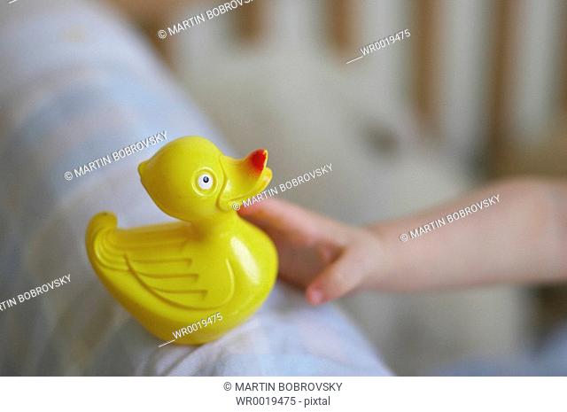 baby grabbing yellow rubber duck