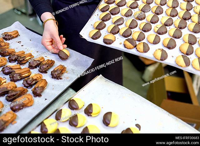 Female baker arranging pastry on tray
