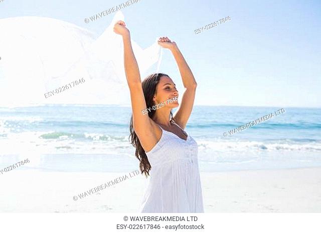 Pretty brunette in white sun dress holding sarong