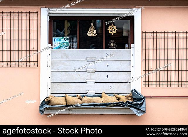13 December 2023, Bavaria, Passau: Sandbags lie in front of a window at a house on the banks of the Danube. The flood situation remains tense in parts of...