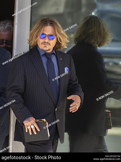 Johnny Depp is reflected in a doorway as he goes outside during a break on the testimony of his trial against Amber Heard during day 4 at the Fairfax County...