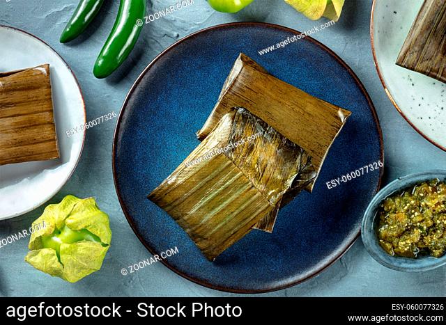 Tamales oaxaquenos, traditional dish of the cuisine of Mexico, various stuffings wrapped in green leaves, overhead flat lay shot. Hispanic food