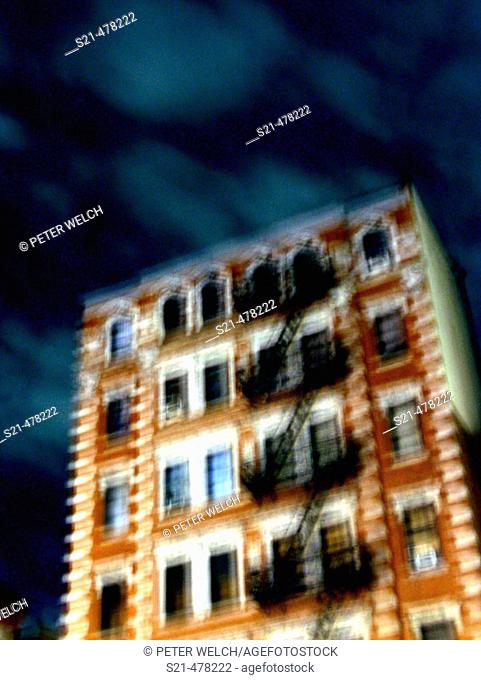 A New York apartment building is captured at night with a blury, pastel effect