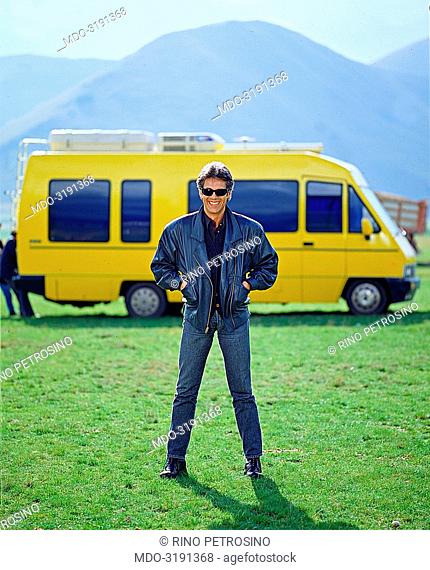 Italian song writer Claudio Baglioni (Claudio Enrico Paolo Baglioni) posing in front of the yellow van which drove him on his tour in ncentral Italy