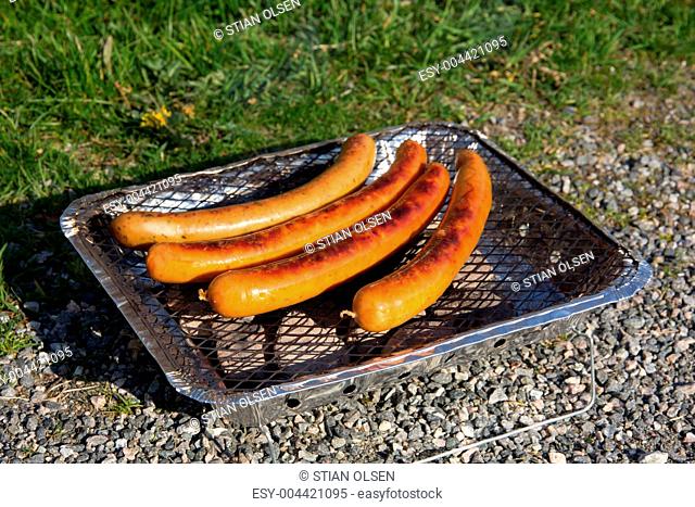 Sausages on one time use grill