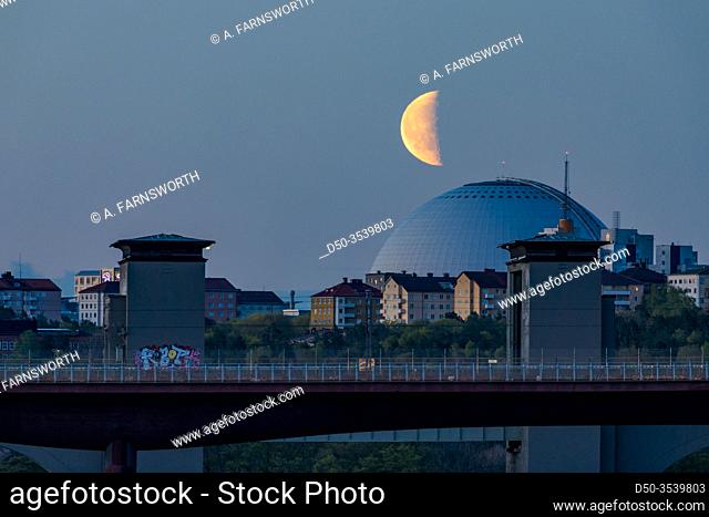 Stockholm, Sweden The Ercisson Globe Arena at night with a half moon rising over the Arsta train bridge