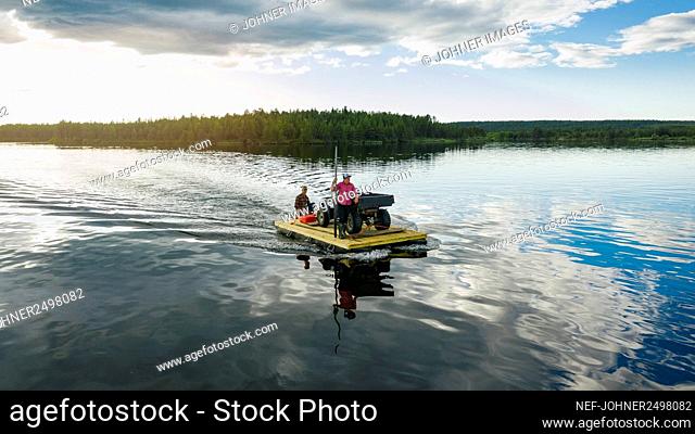People transporting quadbike on motor raft