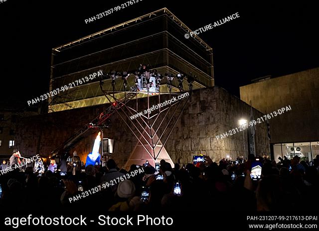 07 December 2023, Bavaria, Munich: Dieter Reiter (SPD), Lord Mayor of Munich, lights the first light on the Hanukkah candelabra in front of the main synagogue...