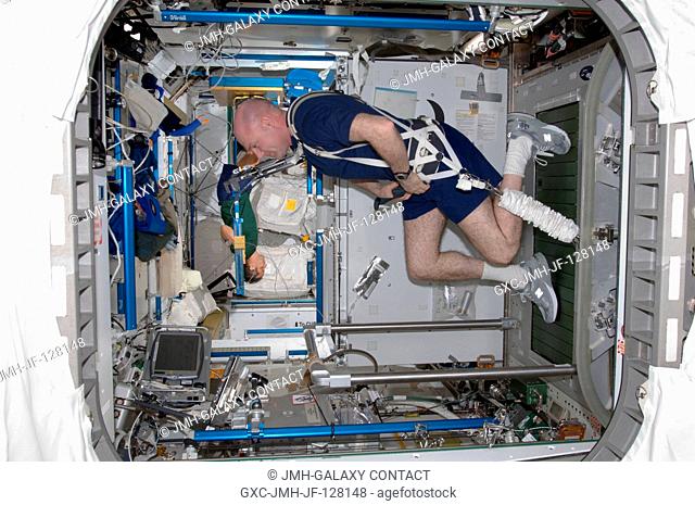 European Space Agency astronaut Andre Kuipers, Expedition 31 flight engineer, equipped with a bungee harness, exercises on the Combined Operational Load Bearing...