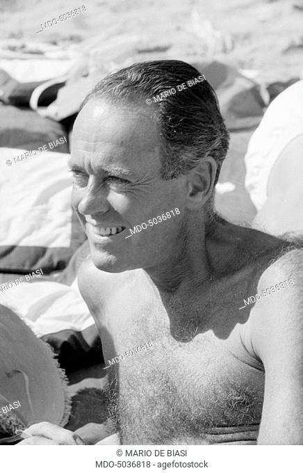 American actor Henry Fonda smiling on the beach during the XVIII Venice International Film Festival. Venice, 1957