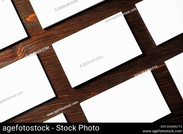 Photo of blank white business cards on wood table background. Template for branding identity