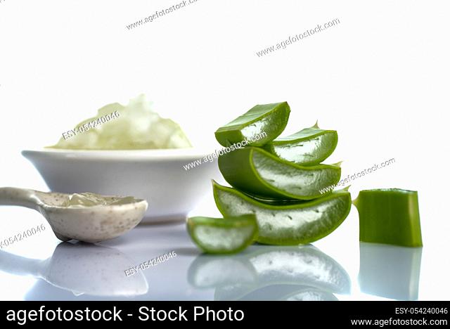 Slices of Aloe Vera leave and Aloe Vera gel in a bowl on a white background. Aloe Vera is a very useful herbal medicine for skin care and hair care