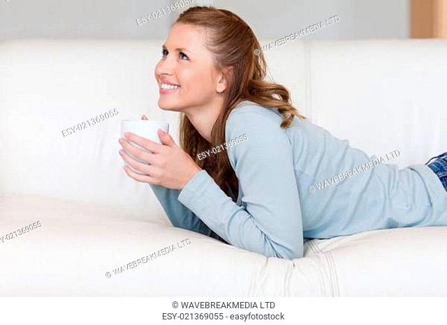 Young female enjoying a coffee break on her couch