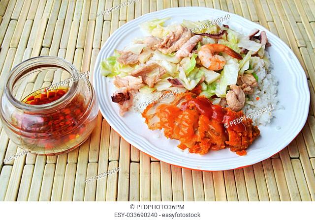 stir fried cabbage with seafood and crispy chicken on rice