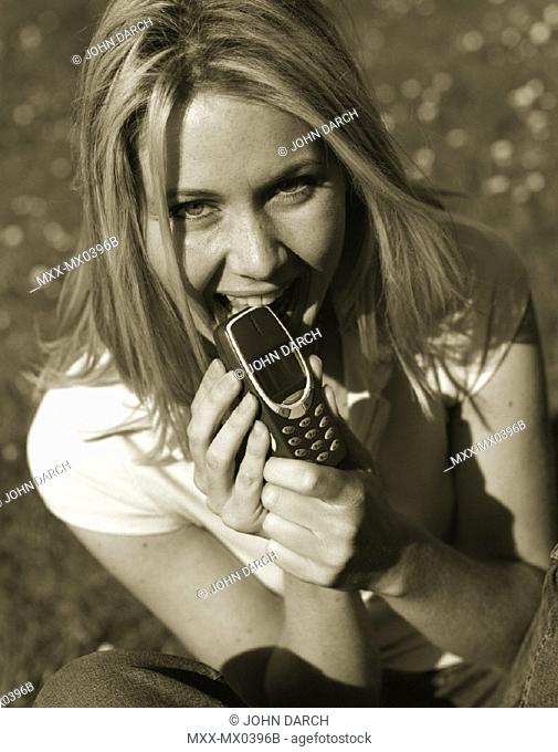 Woman biting cellular phone