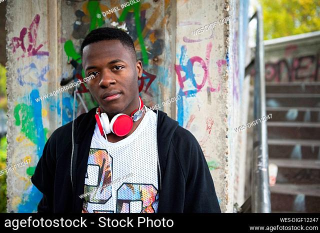 Portrait of young jogger with red headphones in the city