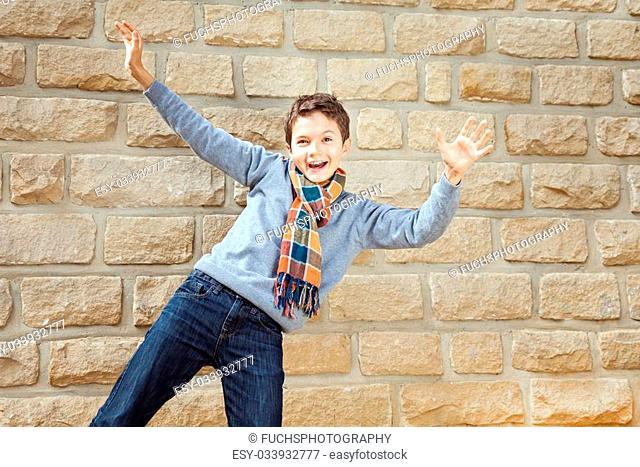 Charming Teenage boy in front of a bright brickwall