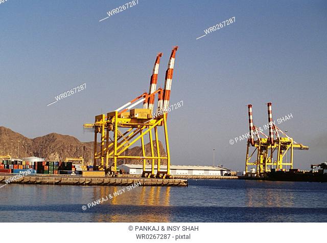 Heavy cranes are seen at the dock under sunlight