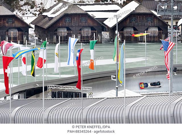 The four-person Bob with Maria Ade Constantini as the Pilot, from Romania passing the echo-curve lined with flags in Schoenau Am Koenigssee, Germany