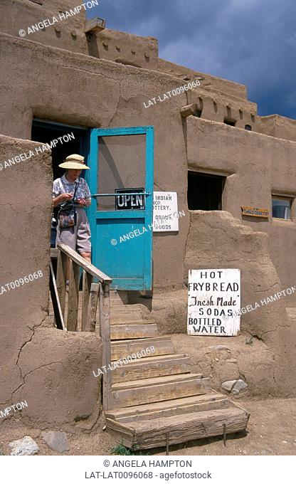 Near Santa Fe. Native American traditional house. Cafe, shop. Woman on step
