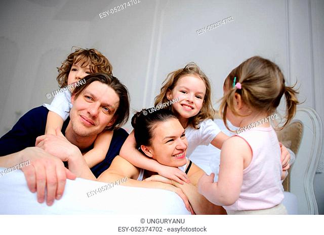 Morning in a big family. Father, mother and three children cheerfully begin new day