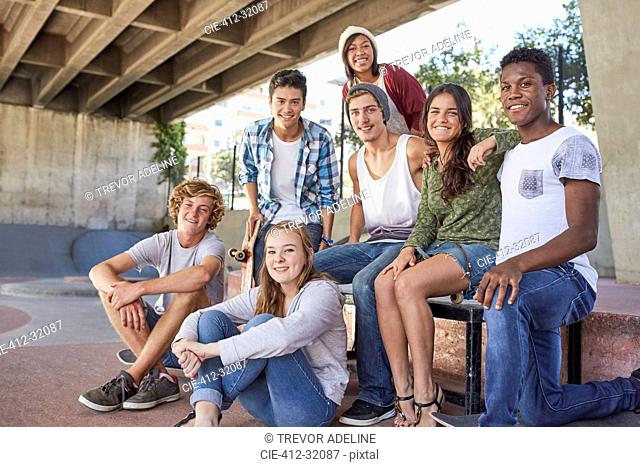 Portrait confident teenage friends hanging out at skate park