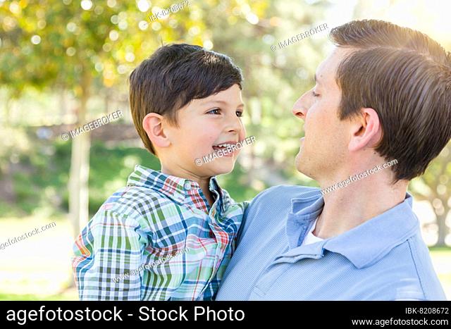 Happy caucasian father and son playing together in the park