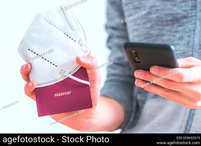 Young man is holding a passport, ffp2 mask and smartphone on the airport, ?passport?