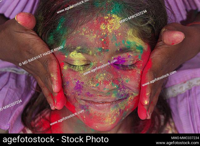 Children with bright colorful painted faces at a Bangladeshi Tea garden during the annual Hindu Festival of Colors, known as Holi Festival marking the onset of...