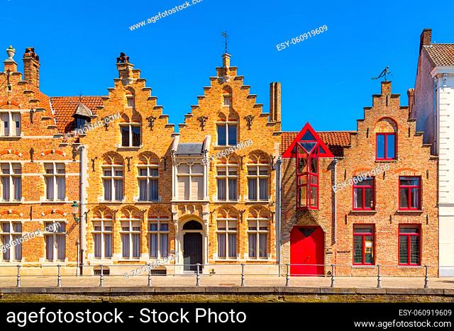 Bruges, Belgium street view panorama with canal and colorful traditional houses against blue sky in popular belgian destination