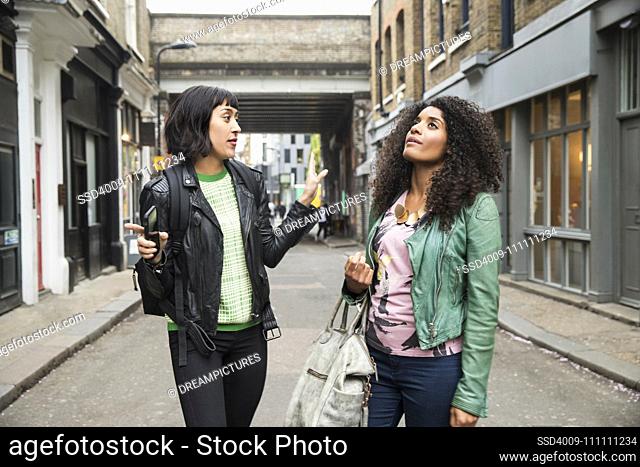 Two women walking and talking on the streets of London