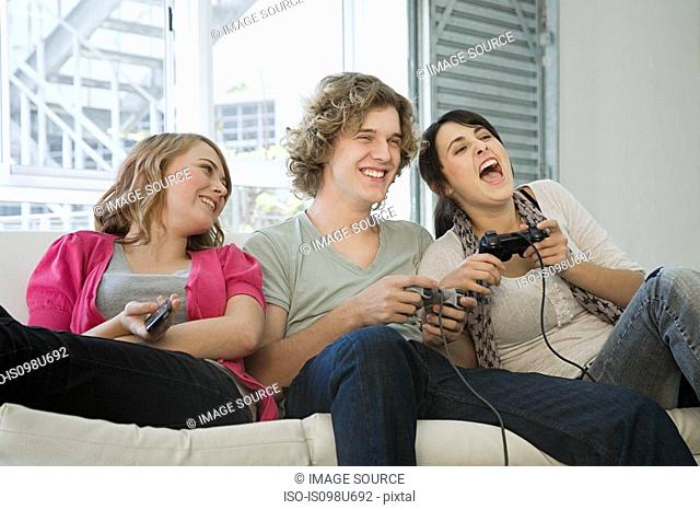 Teenagers playing on games console