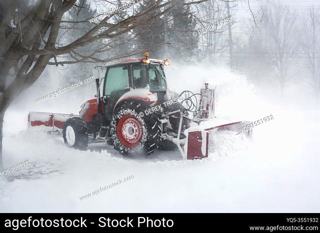 snowblower blowing snow from driveway during blizzard, Meaford, Ontario, Canada