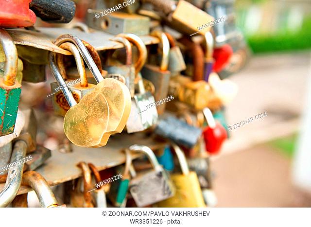 Love golden romance lock with heart shape on the bridge