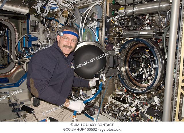 NASA astronaut Dan Burbank, Expedition 30 commander, works on the Combustion Integrated Rack (CIR) in the Destiny laboratory of the International Space Station