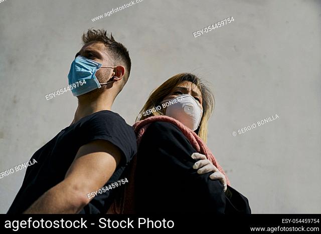 Caucasian male and Asian female wearing medical masks as a defense against a virus. The concept of Coronavirus