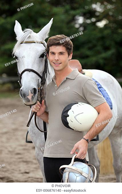 Teenage boy stood with horse