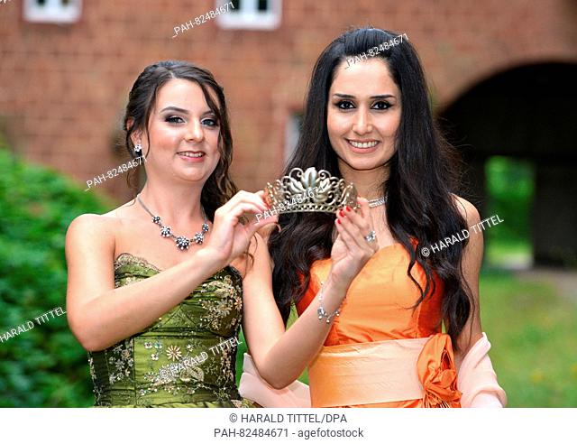 The new Wine Queen of Trier, Ninorta Bahno (26, R) from Syria, and her predecessor Sandra Roth (L) look at the crown ahead of the official crowning in Trier